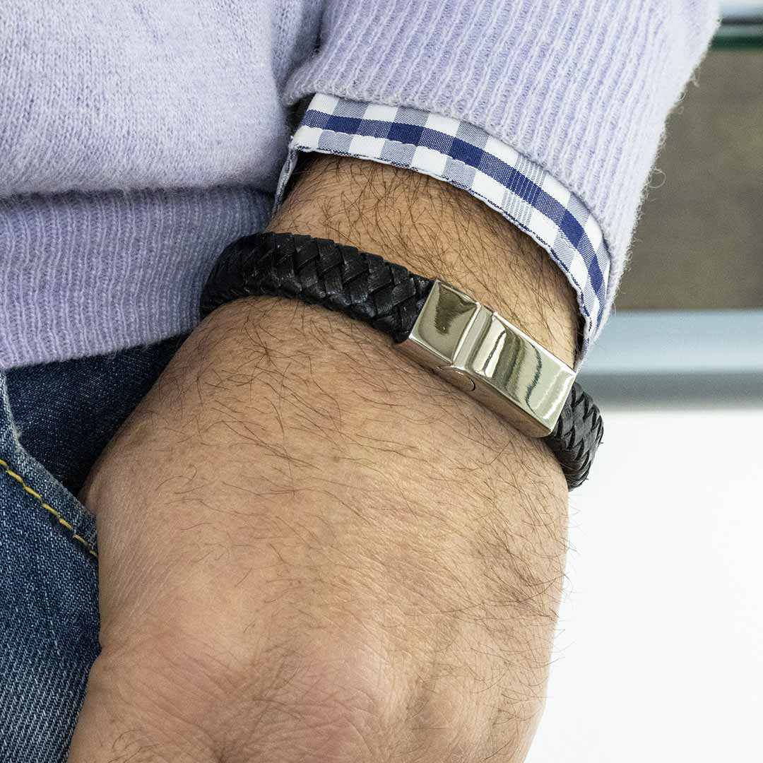 bracciale da uomo in pelle intrecciata nera e acciaio indossato - via condotti store