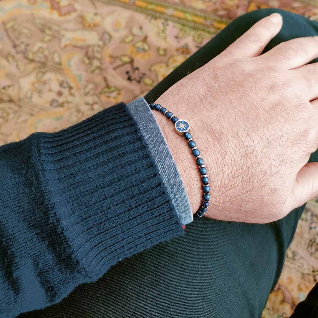 bracciale con sfere e rosa dei venti in acciaio blu indossato da un uomo - via condotti store
