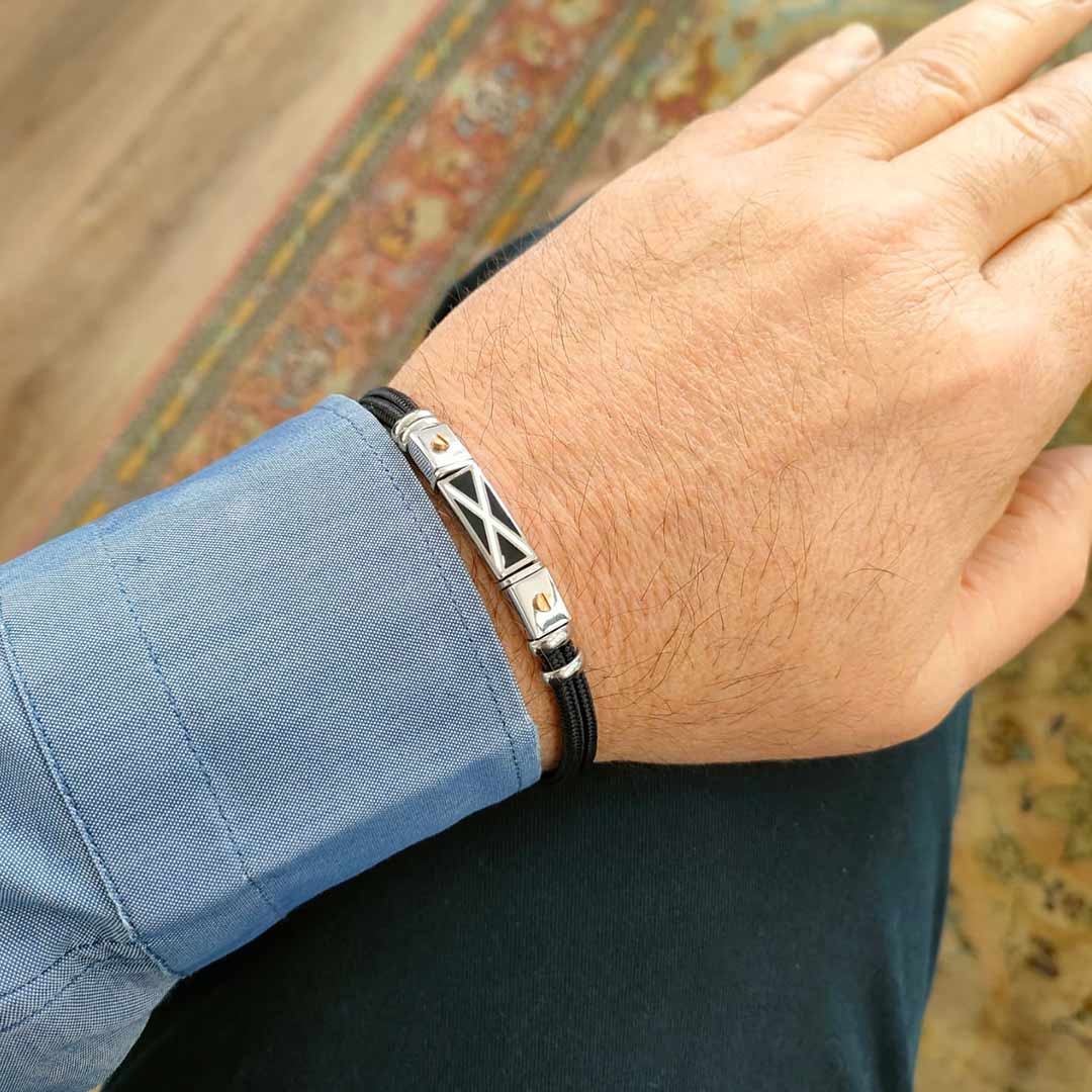 bracciale da uomo con bandierine nautiche in corda nera e acciaio indossato - via condotti store