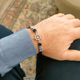 bracciale da uomo in corda nera con timone in acciaio indossato - via condotti store