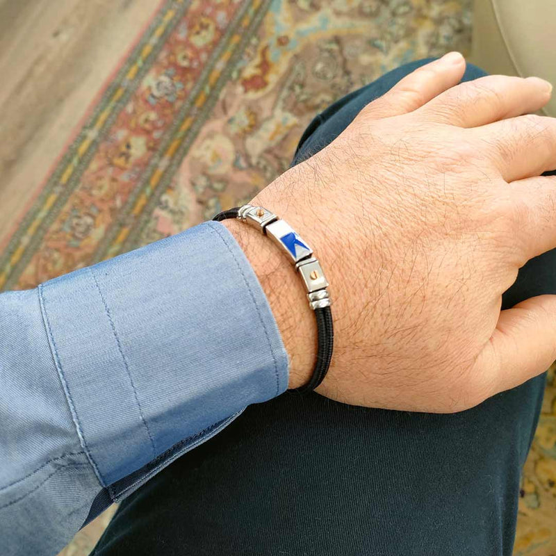 bracciale da uomo con bandierine nautiche in corda nera e acciaio inox indossato - via condotti store