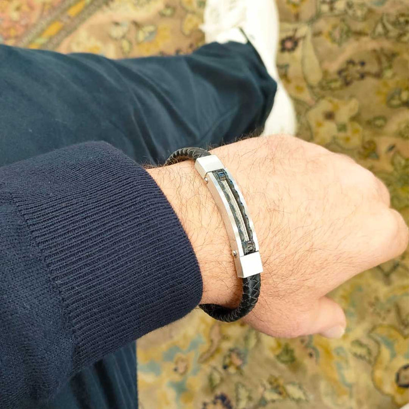 bracciale indossato da uomo in pelle nera intrecciata e piastra con cavetti in acciaio - via condotti store